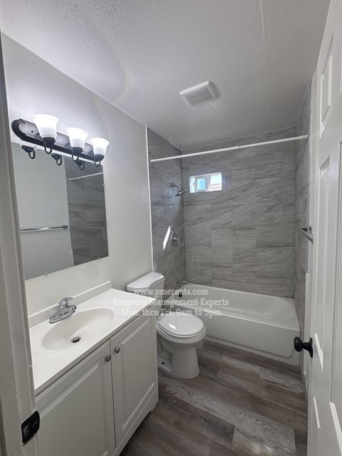 A bathroom with a white sink, toilet, and a bathtub.
