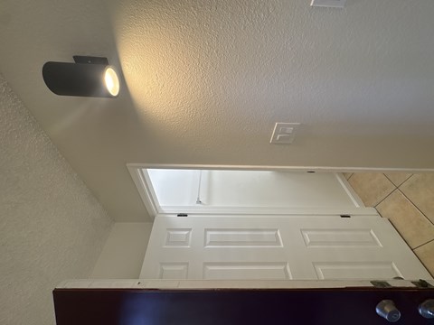A white ceiling with a skylight and a light fixture.