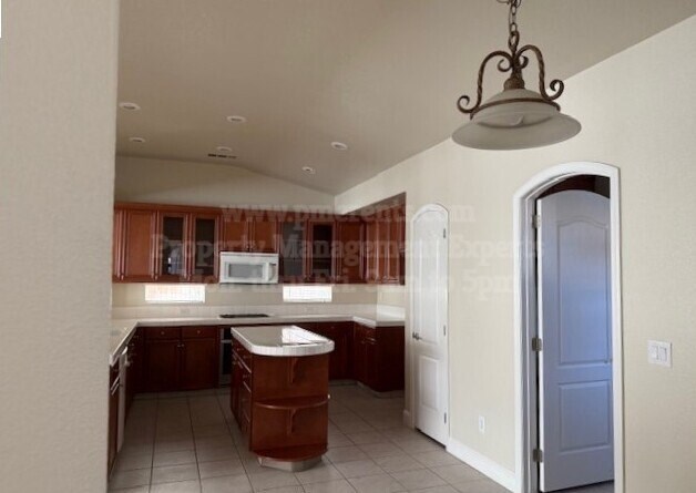 A kitchen with brown cabinets and a white island.
