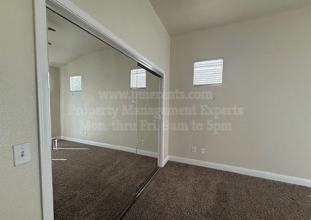 A room with a carpeted floor and a mirror on the wall.