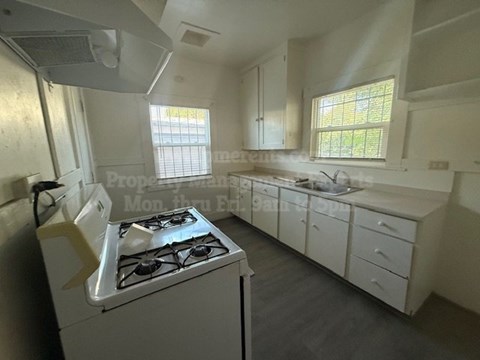 A white kitchen with a stove and cabinets.