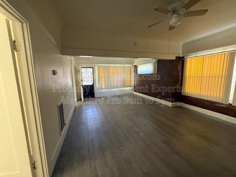 A room with wooden flooring and a ceiling fan.