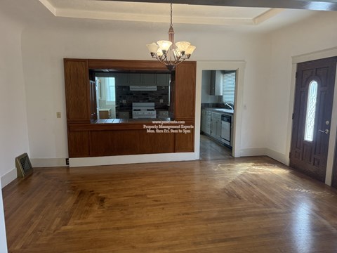 A room with wooden floors and a chandelier.