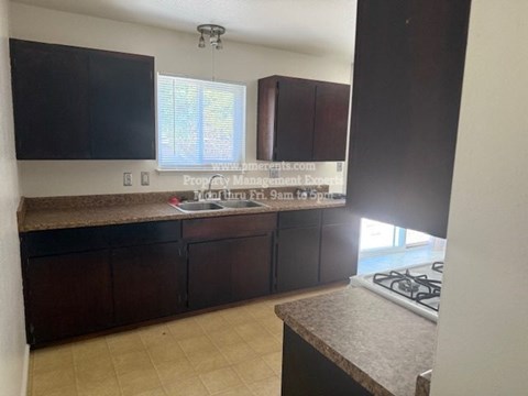 A kitchen with dark brown cabinets and a countertop.