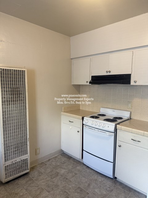 A kitchen with white appliances and cabinets.
