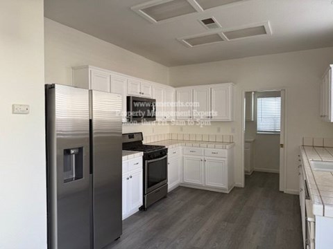 A kitchen with a refrigerator, oven, and microwave.