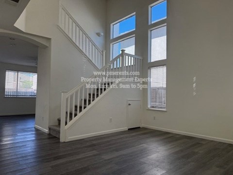 A spacious room with a staircase leading to the upper level.