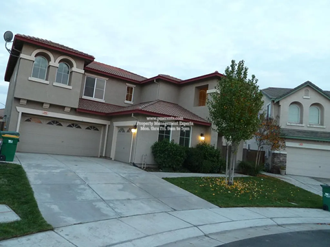 A house with a red roof and a garage door that says "Mrs. Brinley's".