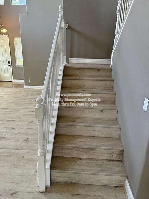 A staircase with a white railing and wooden steps.