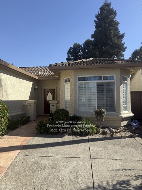 A house with a driveway and a sign in front.