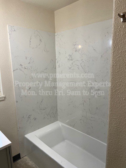 a white bath tub in a bathroom with a sink