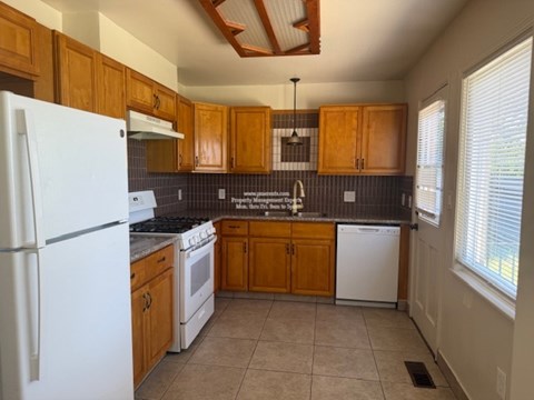 A kitchen with wooden cabinets and a white refrigerator.