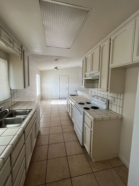 A kitchen with white appliances and cabinets.