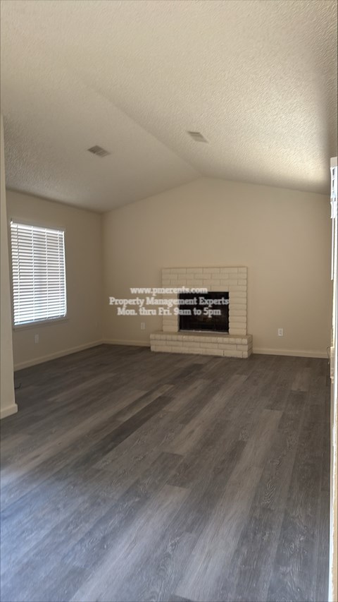 A room with a wooden floor and a sign on the wall.