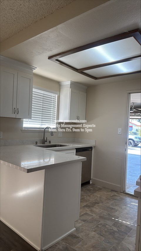 A kitchen with white cabinets and a tiled floor.