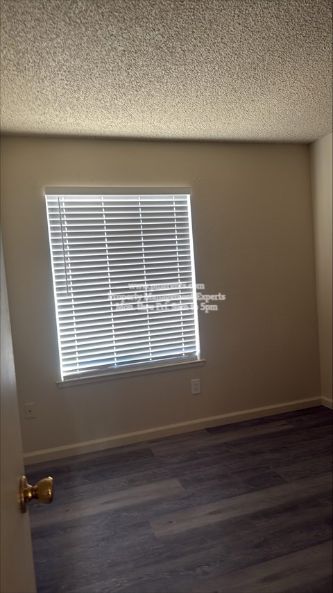 A room with a closed door and a window with blinds.