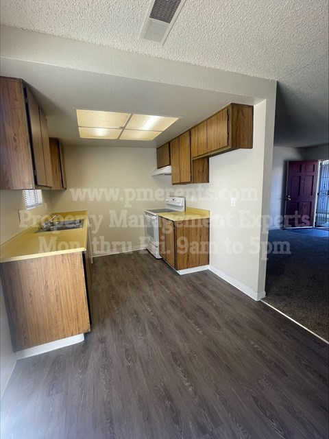 A kitchen with wooden cabinets and a countertop is shown.