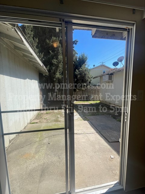 A view from inside a room looking out through a sliding glass door.