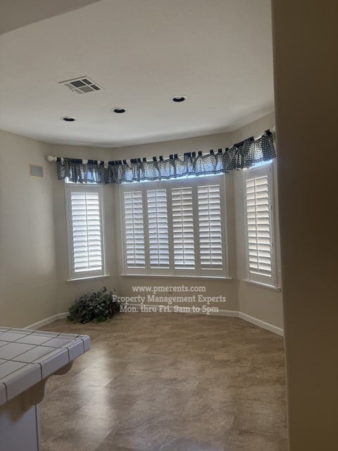 A room with a window covered by a black curtain.