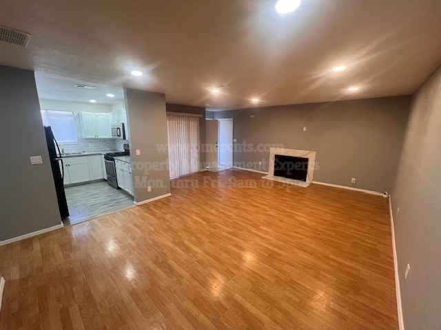 A living room with a fireplace and hardwood floors.