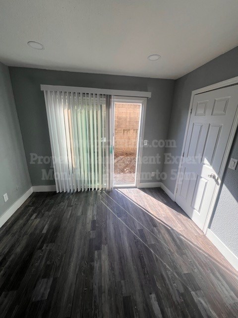 A room with a wooden floor and a white door.