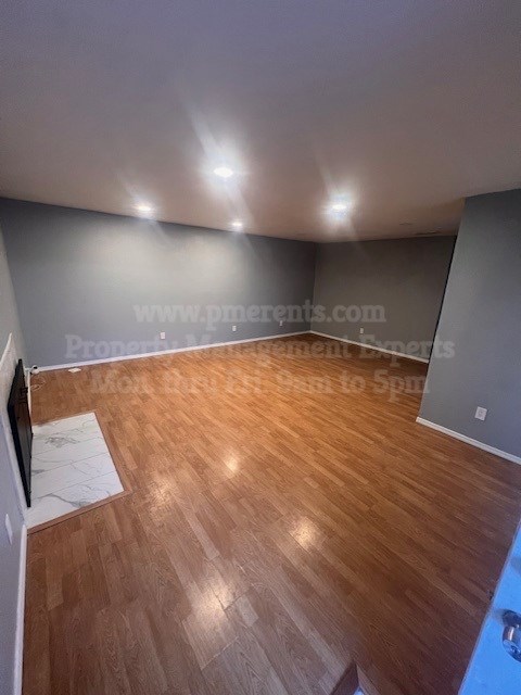 A room with wooden flooring and a website address on the wall.