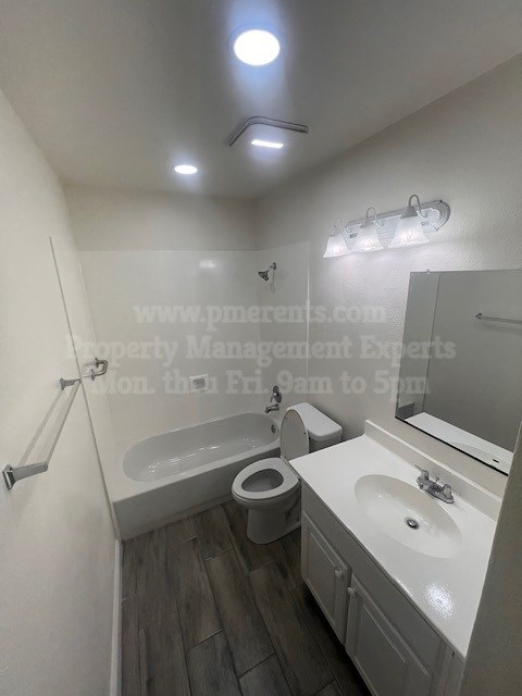 A white bathroom with a toilet, sink, and mirror.