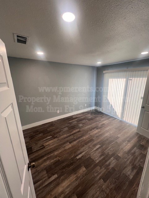 A room with wooden flooring and a white door.