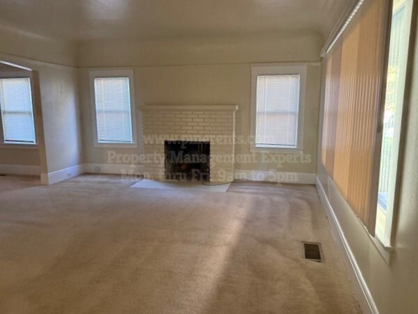 A room with a fireplace and a window.