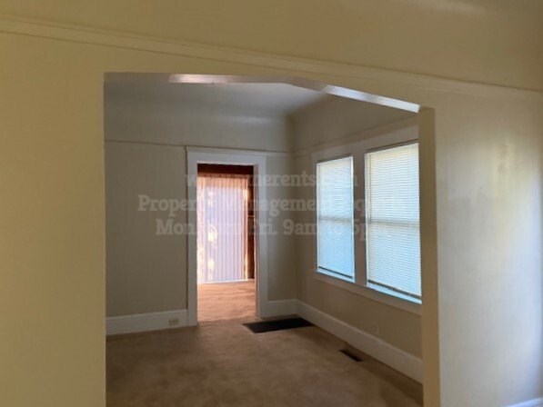 A room with a door and a window with blinds.