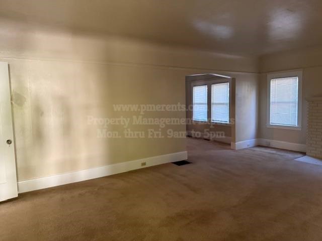 A room with a door, a window, and a wall with a website address written on it.