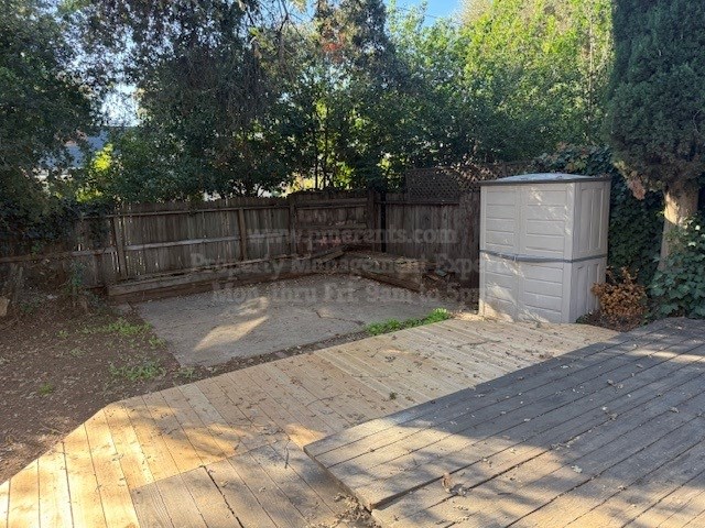 A backyard with a wooden deck and a shed.