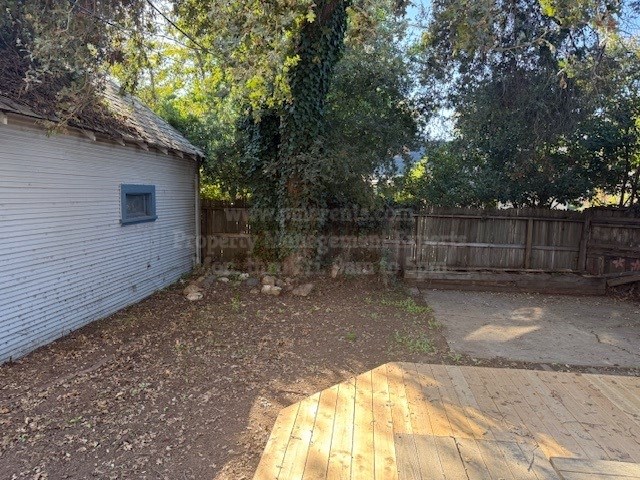 A backyard with a wooden deck and a shed.