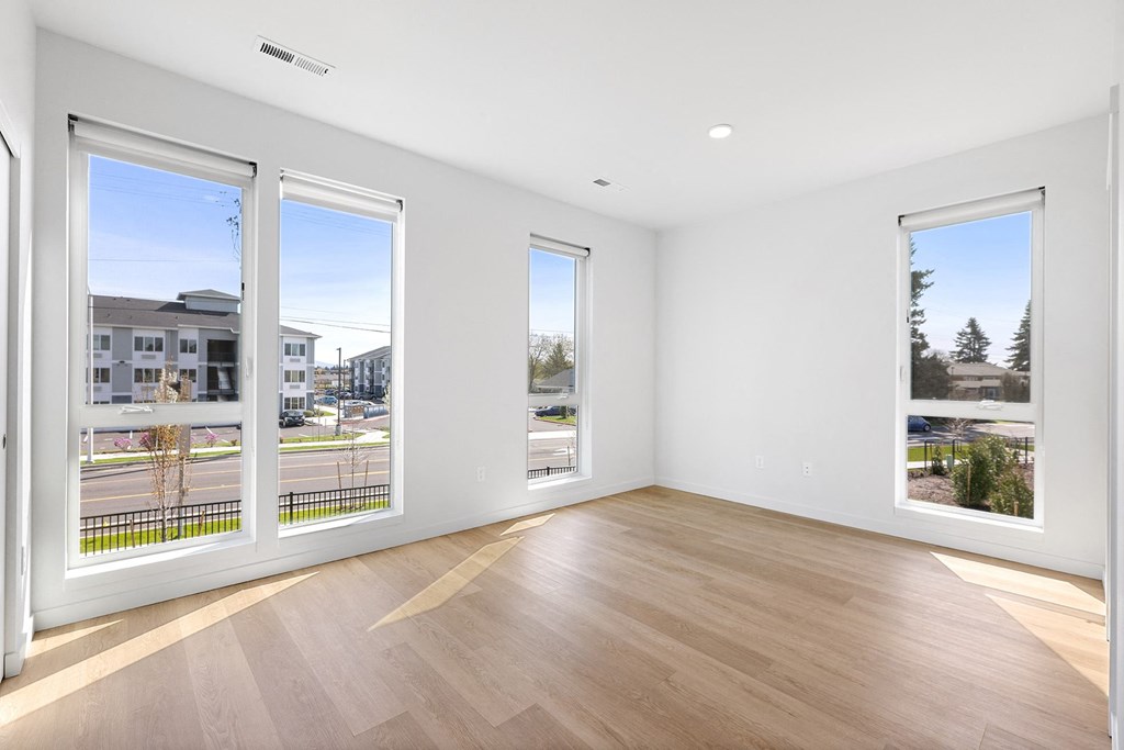 a living room with large windows and a wooden floor