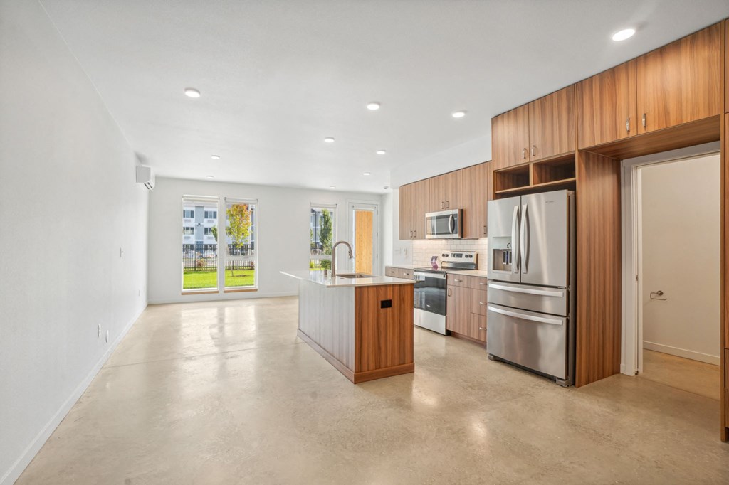a large kitchen with stainless steel appliances and wooden cabinets
