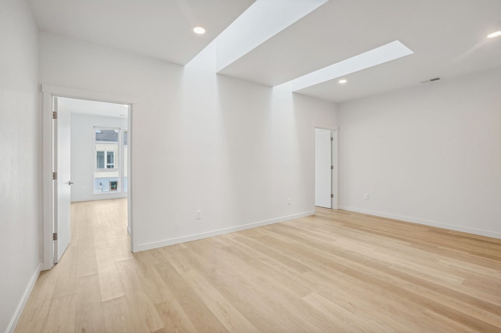 a living room with white walls and wooden floors
