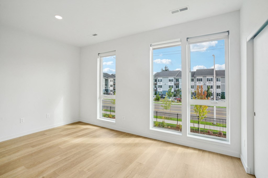 an empty living room with a row of windows