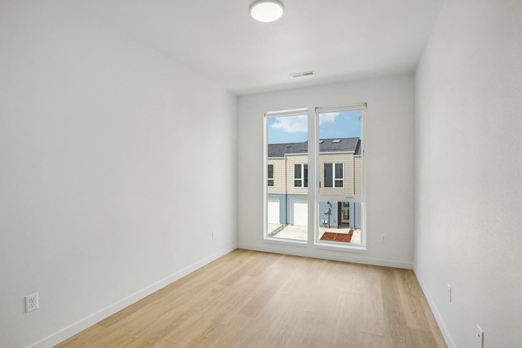 a living room with white walls and a window