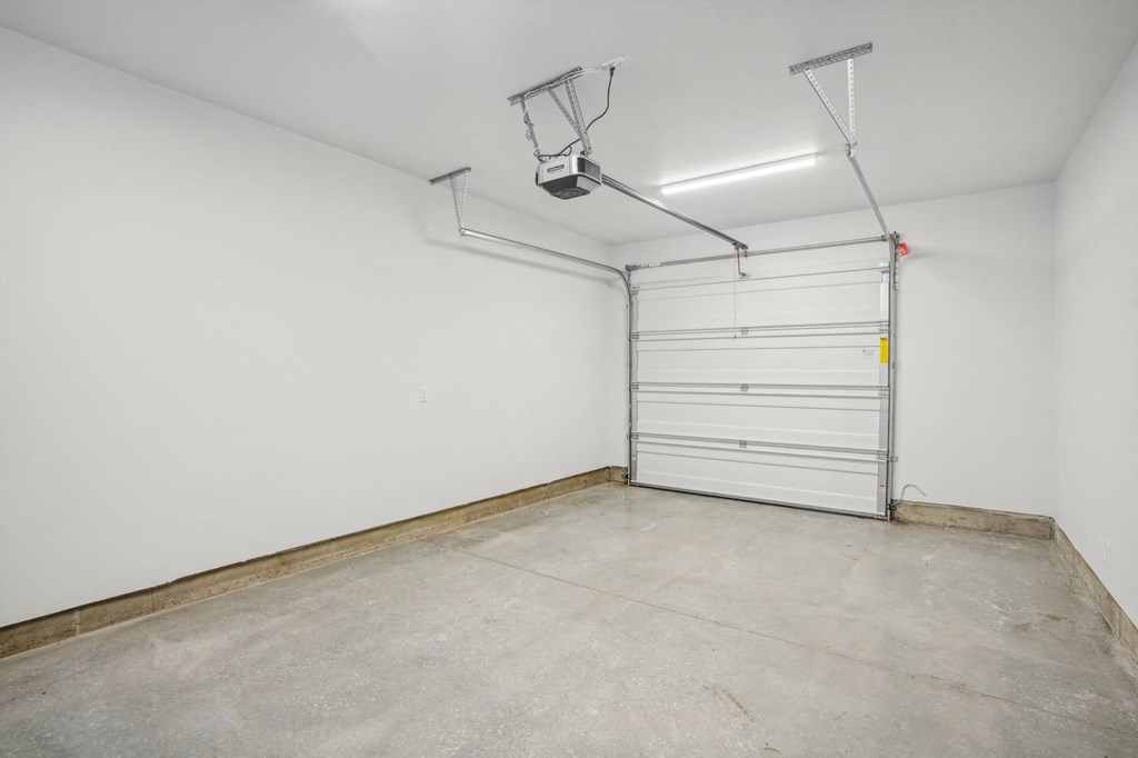 a empty garage with a white wall and a garage door