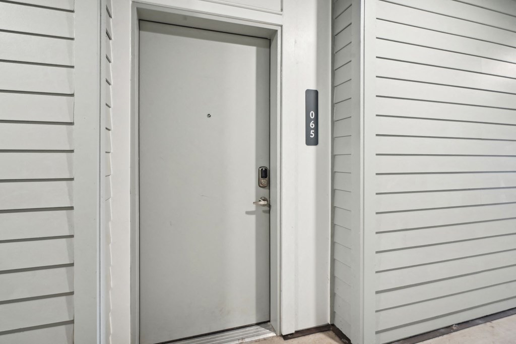 the front door of a house with a white door with a silver handle