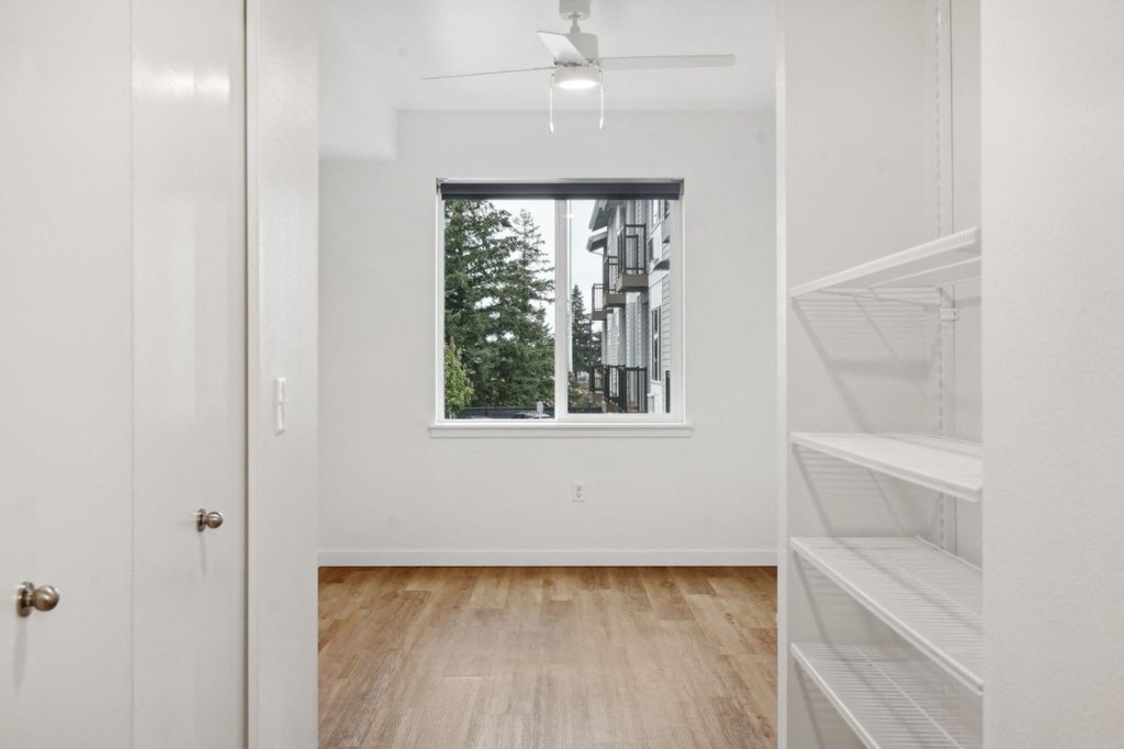 an empty room with a window and a closet