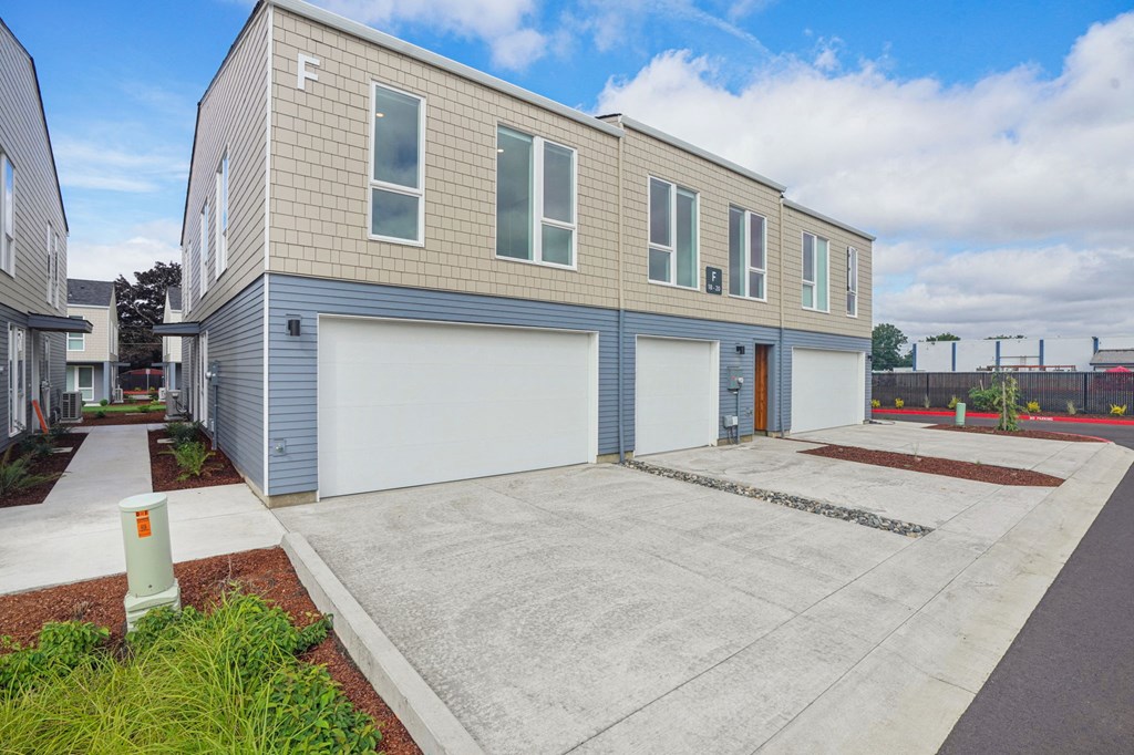 an empty parking lot in front of a building with a garage door