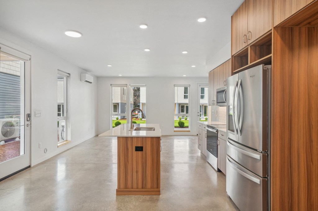 a large kitchen with stainless steel appliances and wooden cabinets