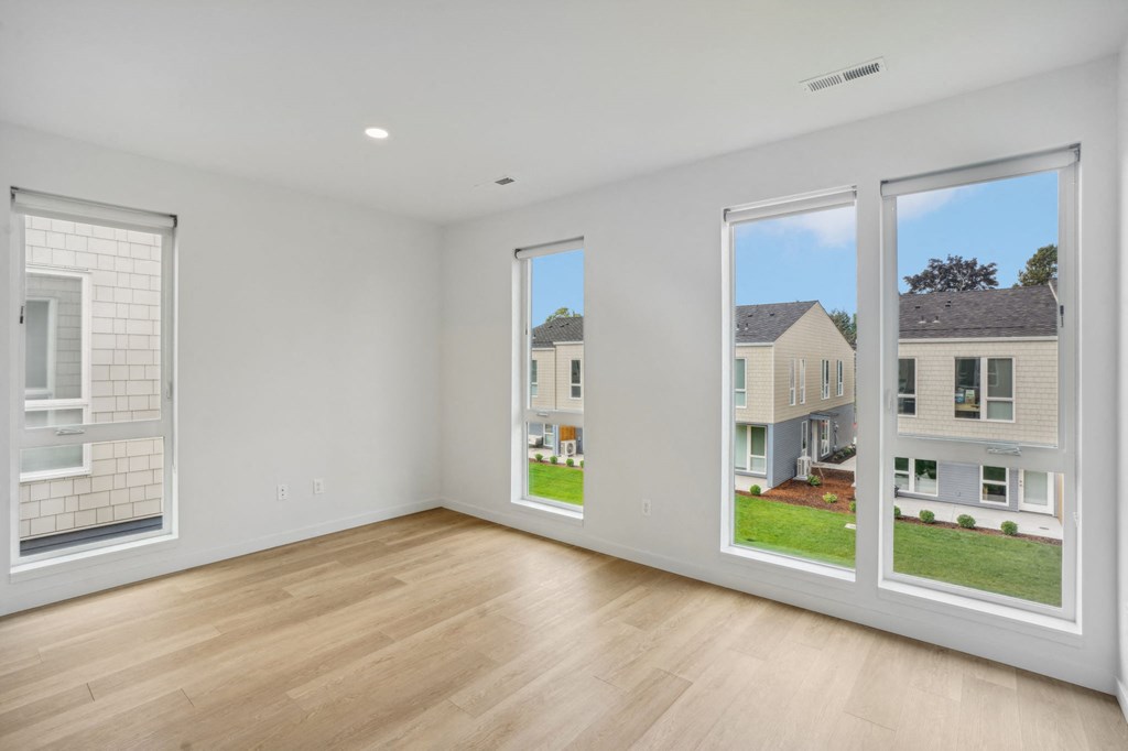 a living room with large windows and a wooden floor