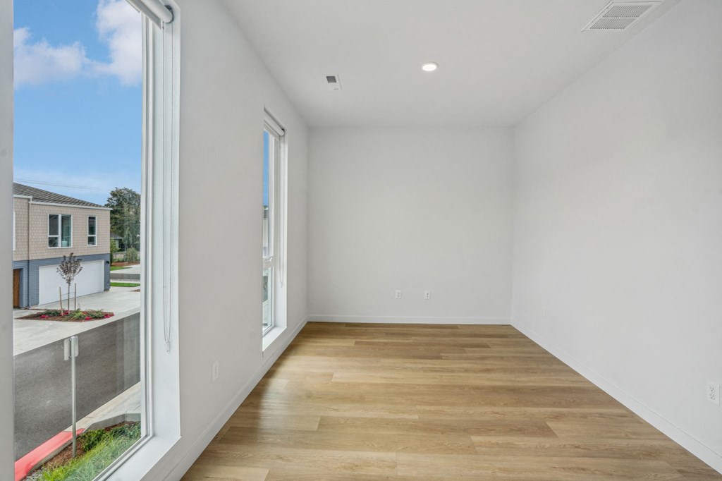 a living room with a large window and a wooden floor