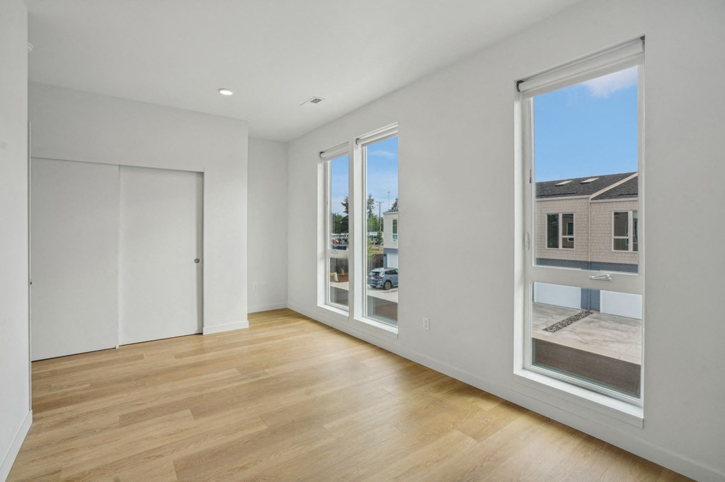 a living room with large windows and a door to a street