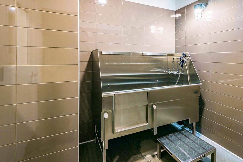 a stainless steel sink in a bathroom with a bench