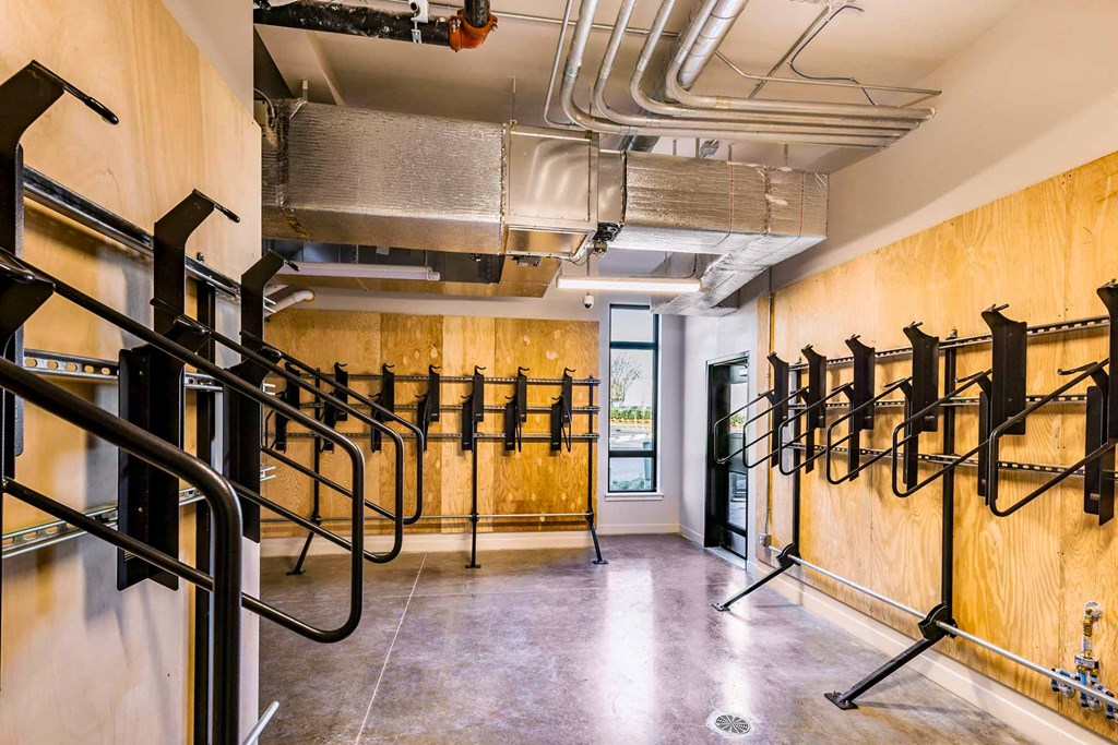 a fitness room with cardio equipment on the wall and a door