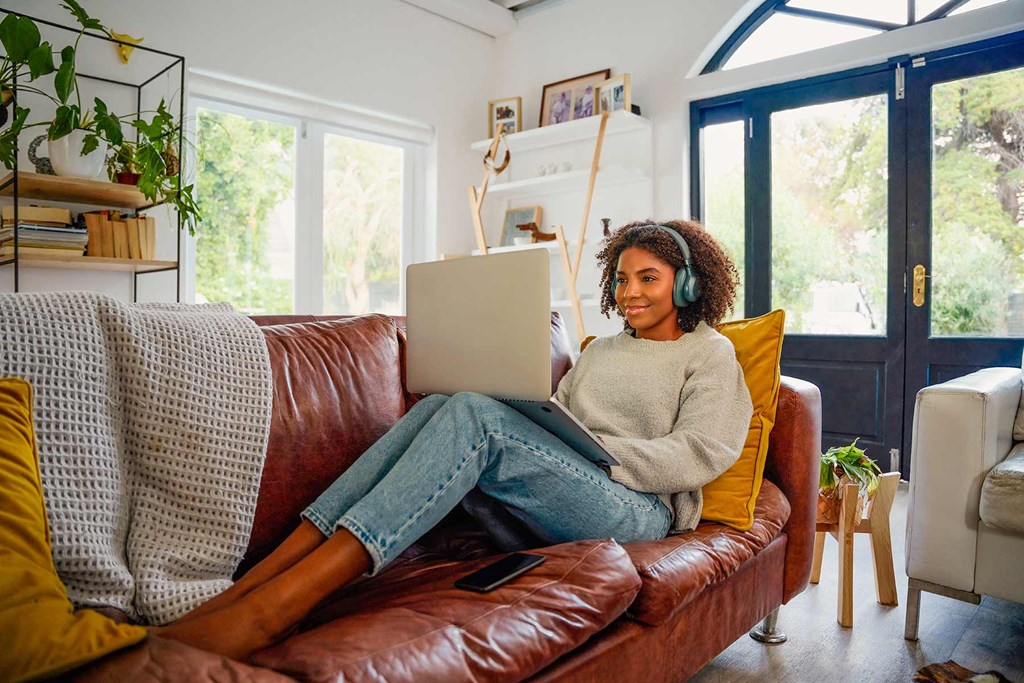 a woman sitting on a couch with a laptop computer