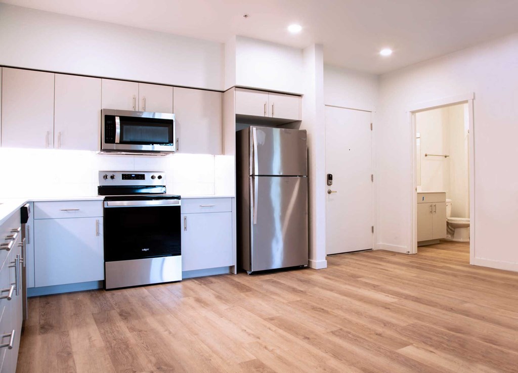 a kitchen with a refrigerator freezer and a stove top oven